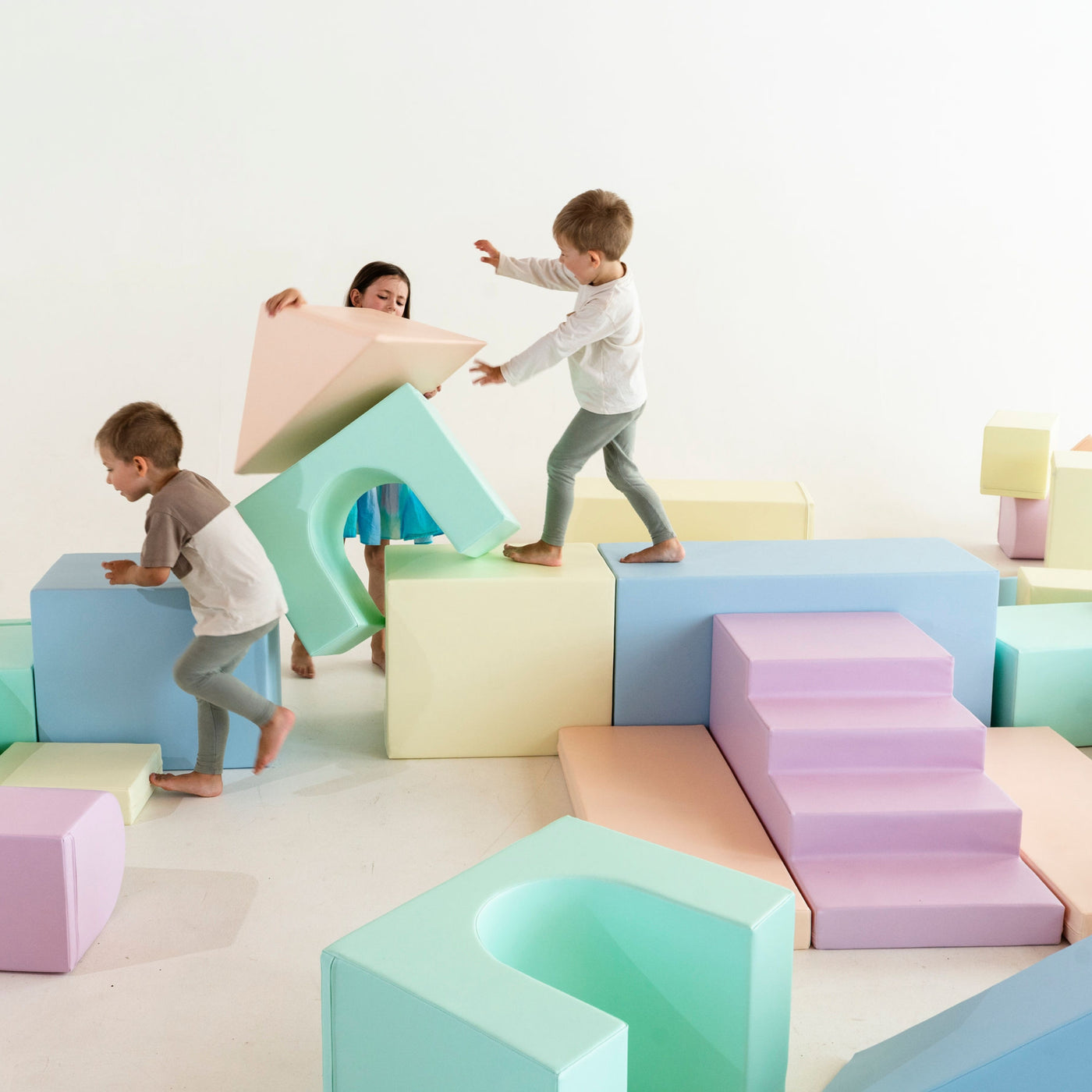 Toddler climbing on a foam soft play block set during a birthday party