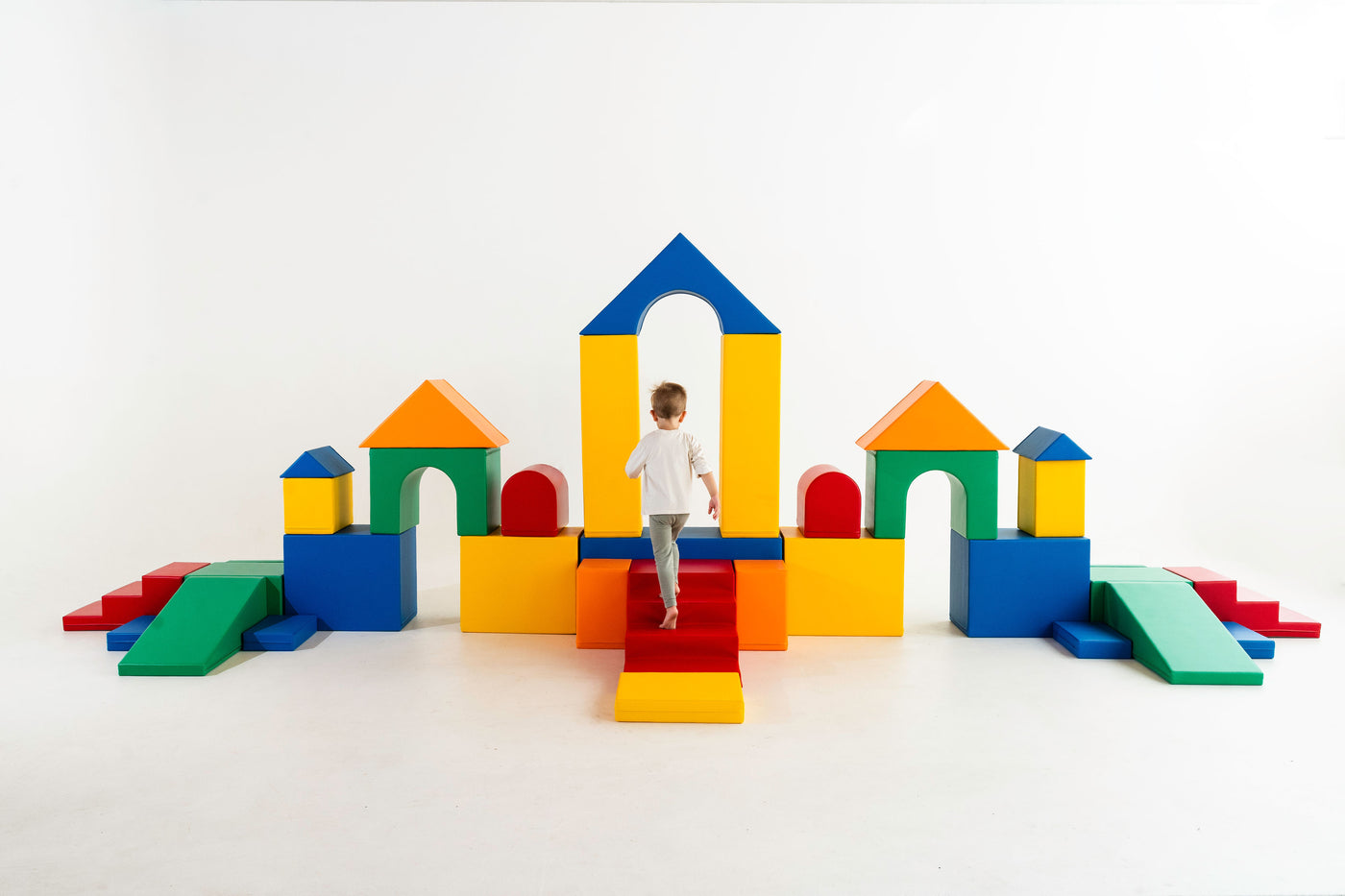 Foam soft play tunnel and slide set up as part of a larger party layout
